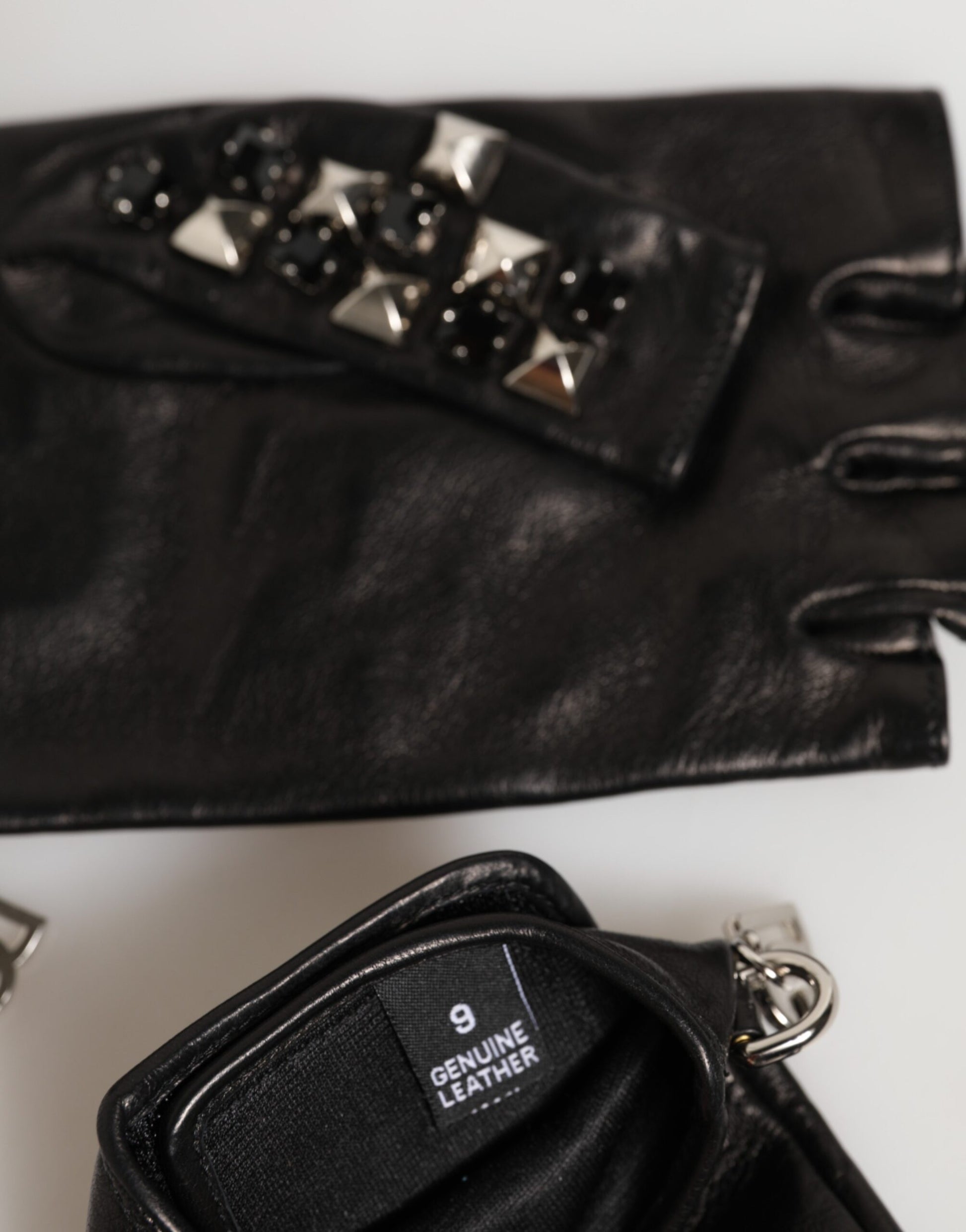 Close-up detail of Dolce & Gabbana black studded leather fingerless gloves by KILAUE
