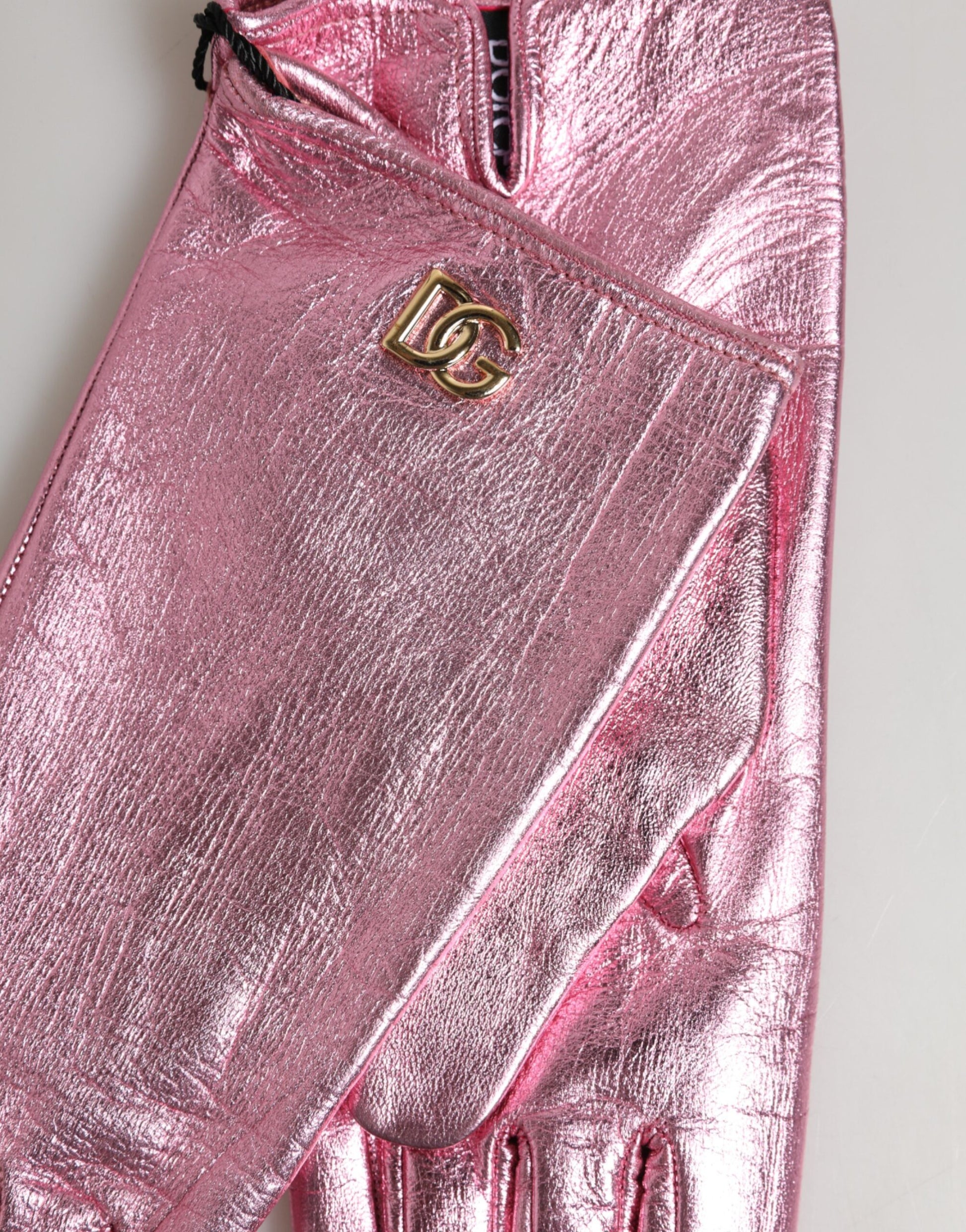 Close-up detail of Dolce & Gabbana pink leather DG logo wrist-length mittens by KILAUE

